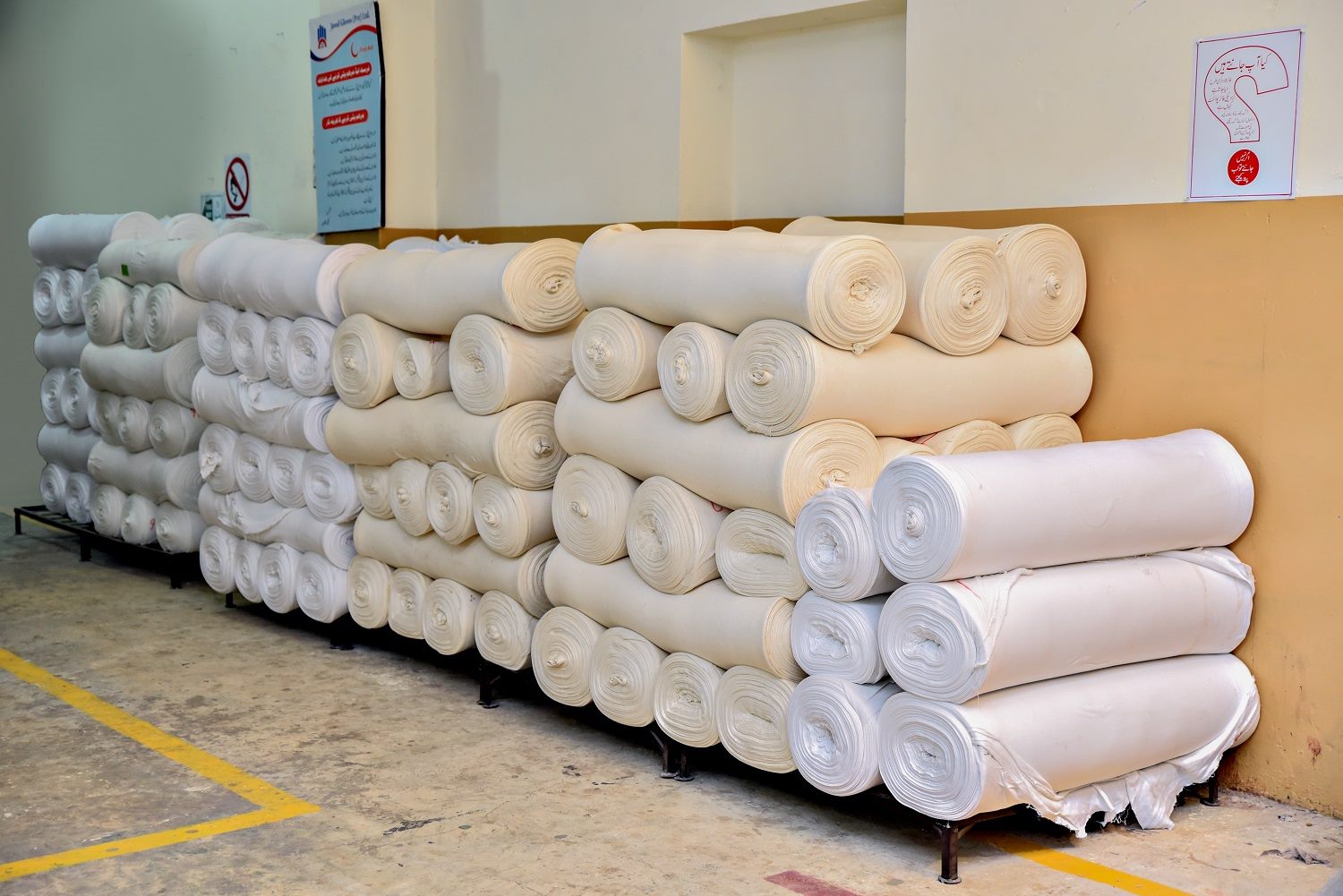 Rolls of finished cotton fabric stacked in the workshop